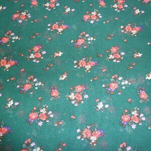 Fabric with pink, red, and fuchsia floral pattern on a forest green background